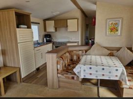 A kitchen area with a table and sofa at Golden Sands Haven, Sunflower Haven, Mablethorpe