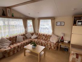 A living room with a sofa and coffee table at Golden Sands Haven, Sunflower Haven in Mablethorpe