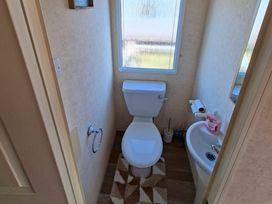 A bathroom with a toilet and a wash basin at Golden Sands Haven, Sunflower Haven in Mablethorpe