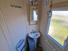 A bathroom with a sink and mirror at Golden Sands Haven, Sunflower Haven Mablethorpe