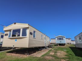 A row of static caravans on a grassy area at Spruces 30 Sandy Bay, Exmouth