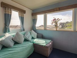 A snug with a sofa and window at Spruces 30 Sandy Bay, Exmouth
