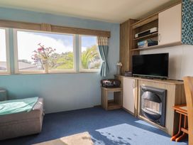 A snug with a sofa and television at Spruces 30, Sandy Bay, Exmouth