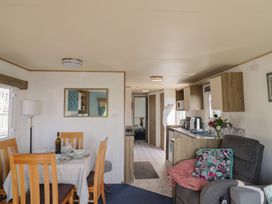 A living room and kitchen with dining table chairs and furniture at Spruces 30 Sandy Bay Exmouth