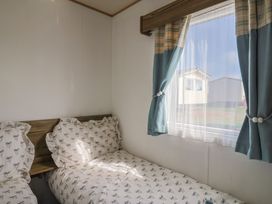 A bedroom with two beds and curtains at Spruces 30 Sandy Bay, Exmouth