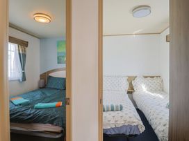 A bedroom with a double bed and twin beds at Spruces 30 Sandy Bay, Exmouth