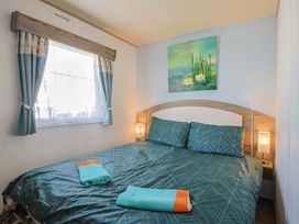 A bedroom with a bed and bedside lamps at Spruces 30 Sandy Bay, Exmouth