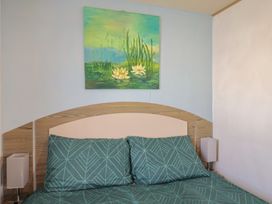 A bedroom with a bed and a painting at Spruces 30, Sandy Bay, Exmouth