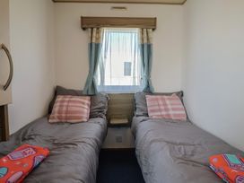 A bedroom with two beds and a window at Spruces 30, Sandy Bay, Exmouth