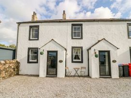 A house with a table and chairs in the outdoor area at Holly in Cleator