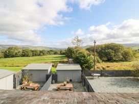 A garden with sheds and tables at Holly in Cleator