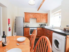 A kitchen with wooden cabinets and appliances at Holly in Cleator