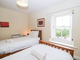 A bedroom with two beds and a window at Holly in Cleator