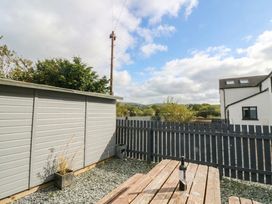 A garden with a wooden table and a shed at Holly in Cleator