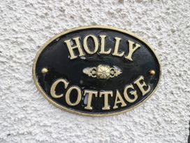 A nameplate displaying 'Holly Cottage' on a wall at Holly in Cleator