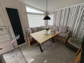 A dining room with a table and sofa at Ty Mawr Holiday Park Swift Toronto Lodge, Abergele