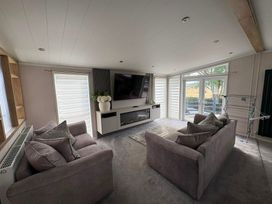 A living room with a sofa and television at Ty Mawr Holiday Park Swift Toronto Lodge in Abergele