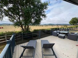 An outdoor deck with chairs and a table at Ty Mawr Holiday Park Swift Toronto Lodge in Abergele