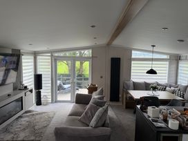 A living room with a sofa and dining table at Ty Mawr Holiday Park Swift Toronto Lodge Abergele