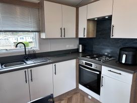 A kitchen with a stove, oven, sink, and air fryer at Club Sahara in Sandy Bay, Exmouth