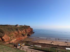 A beach with cliffs and people at Club Sahara Sandy Bay Exmouth