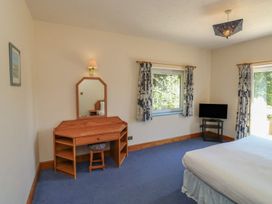 A bedroom with a bed, desk and mirror at Willow in Kingsteignton