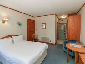 A bedroom with a bed and a chair at Tor in Kingsteignton