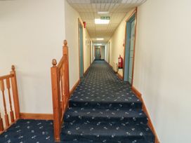 A hallway with a staircase and doors at Tor in Kingsteignton