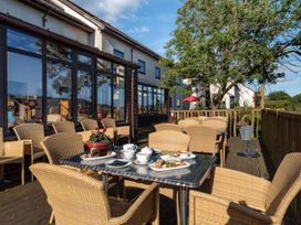 An outdoor patio with chairs and a table at Mallard in Kingsteignton