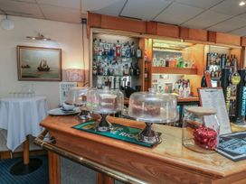 A bar with a counter and liquor bottles at Kestrel in Kingsteignton