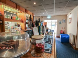 A bar area with a cake display and alcohol bottles at Moorland in Kingsteignton