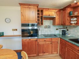 A kitchen with wooden cabinets and appliances at Oakwood in Kingsteignton