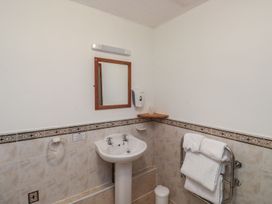 A bathroom with a sink and mirror at Oakwood in Kingsteignton
