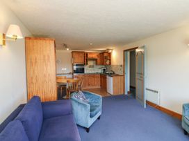 A living room with kitchen and dining table at Tern in Kingsteignton