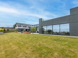 A garden with a house and large windows at Huxham View & Annex in Kingsteignton