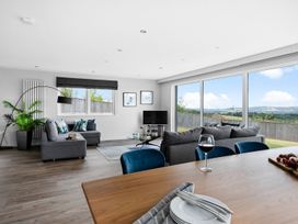 A living room with a sofa and television at Huxham View & Annex in Kingsteignton
