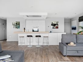A kitchen with an island and stools at Huxham View & Annex in Kingsteignton