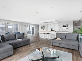 A living room with sofas and a kitchen island at Huxham View & Annex in Kingsteignton