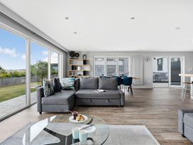 A living room with a sofa and glass table at Huxham View & Annex in Kingsteignton