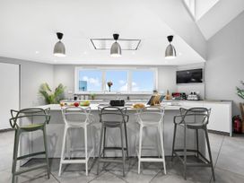 A kitchen with bar stools and cooking utensils at Huxham View & Annex in Kingsteignton