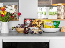 A kitchen counter with snacks and flowers at Huxham View & Annex in Kingsteignton