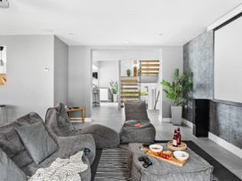 A living room with a sofa and snacks on a table at Huxham View & Annex in Kingsteignton