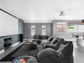 A snug with a projector and large sofa at Huxham View & Annex in Kingsteignton