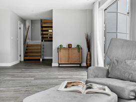 A living room with a staircase and storage cabinet at Huxham View & Annex in Kingsteignton