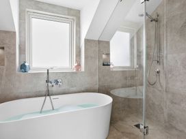 A bathroom with a bathtub and shower at Huxham View & Annex in Kingsteignton