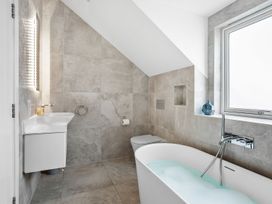 A bathroom with a bathtub, toilet and sink at Huxham View & Annex in Kingsteignton
