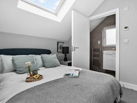 A bedroom with a bed and a doorway to a bathroom at Huxham View & Annex Kingsteignton