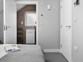 A bedroom with a bed and a door leading to a bathroom at Huxham View & Annex Kingsteignton