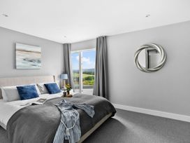 A bedroom with a bed and sliding door at Huxham View & Annex Kingsteignton