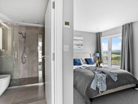A bathroom with shower and a bedroom with a bed at Huxham View & Annex in Kingsteignton